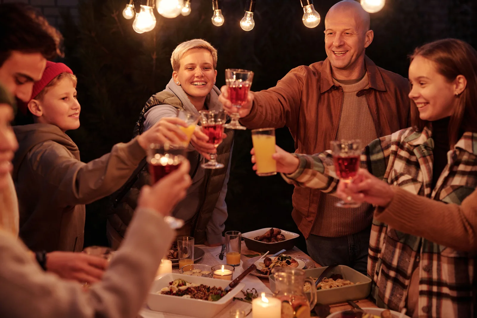 Guests raising and clinking glasses at an outdoor table