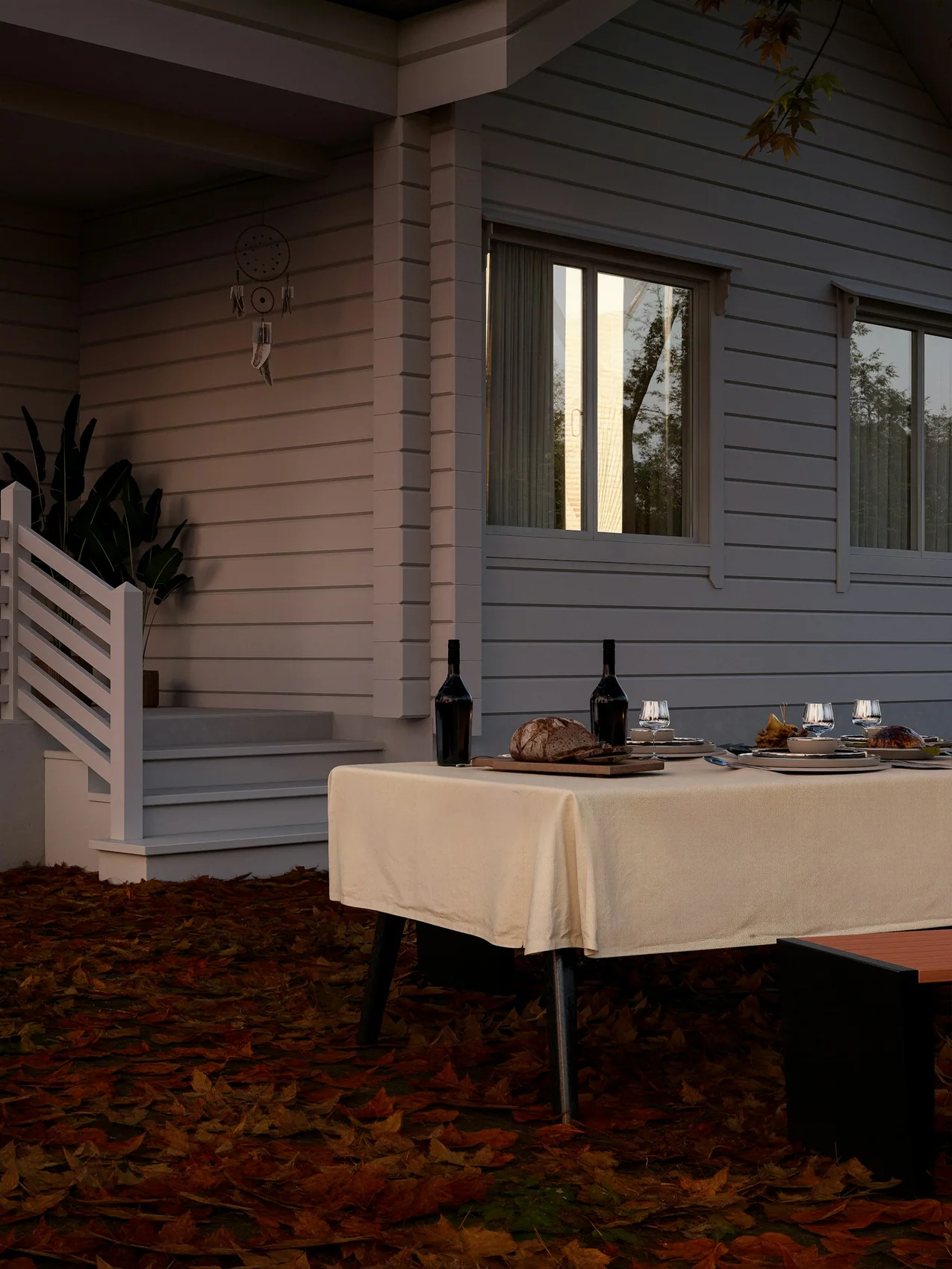 A table laid for dinner outdoors on a cool evening, lit by lanterns