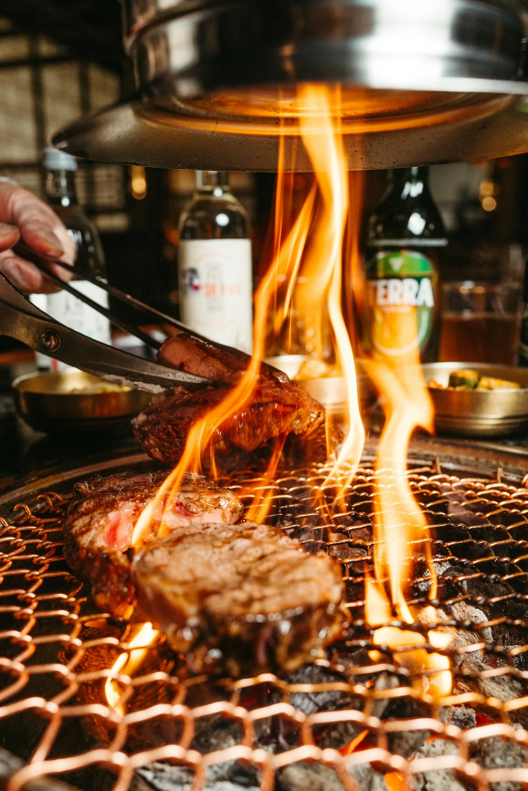 Steak and vegetables cooking over flame, ready to be plated